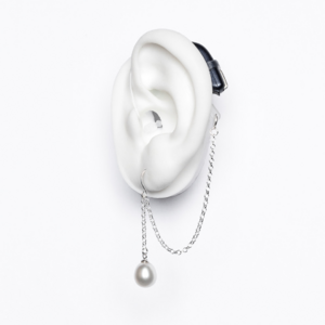 White ear mould shows pearl earring in silver with chain